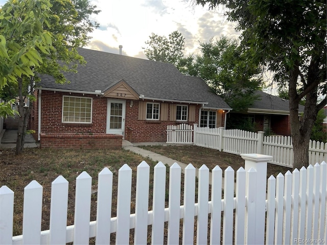 527 S Bryant St, Denver, CO 80219 - cape cod home with brick siding, a fenced front yard, and a shingled roof