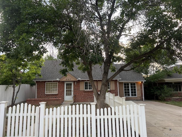 527 S Bryant St, Denver, CO 80219 - view of front of home featuring brick siding, roof with shingles, and a fenced front yard