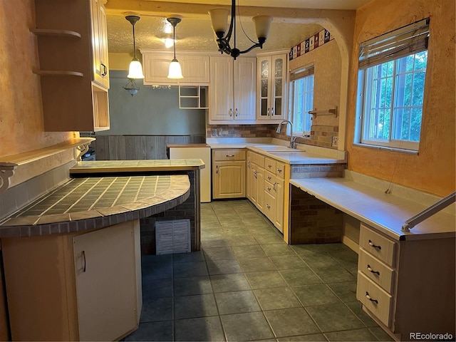 527 S Bryant St, Denver, CO 80219 - kitchen with glass insert cabinets, backsplash, dark tile patterned flooring, open shelves, and wainscoting