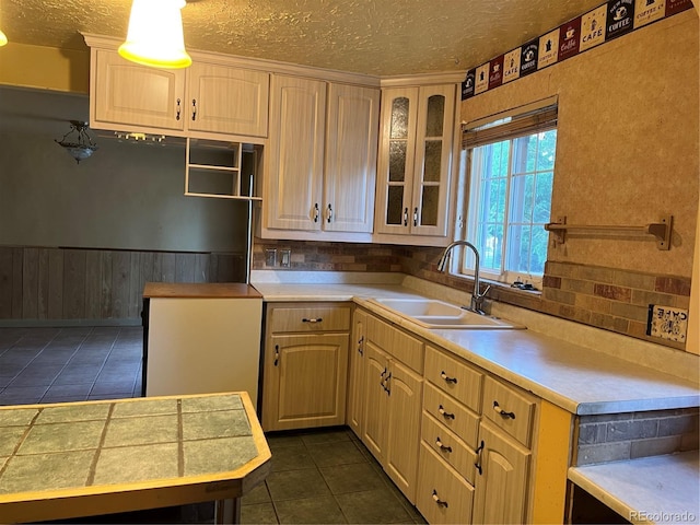 527 S Bryant St, Denver, CO 80219 - kitchen with dark tile patterned floors, a textured ceiling, light countertops, and tasteful backsplash
