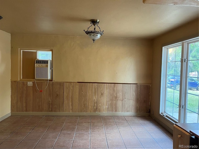 527 S Bryant St, Denver, CO 80219 - empty room featuring a wainscoted wall, healthy amount of natural light, wood walls, and light tile patterned floors