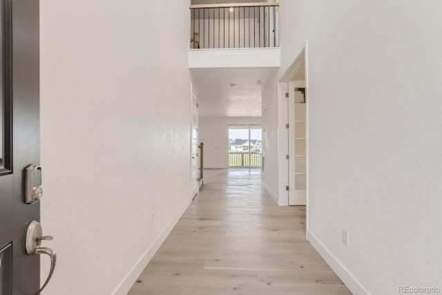 hallway with baseboards and light wood-style floors