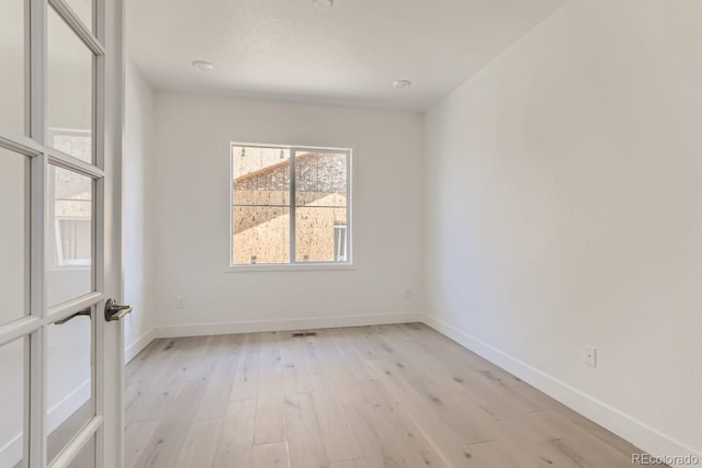 empty room featuring baseboards and light wood-style flooring