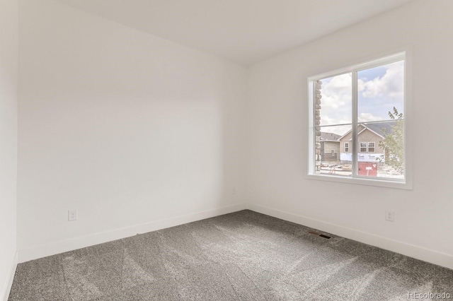 unfurnished room featuring visible vents, baseboards, and carpet