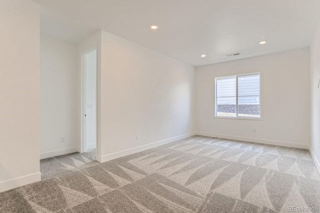 empty room featuring recessed lighting, visible vents, light colored carpet, and baseboards