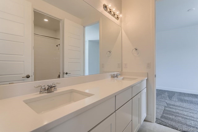 full bathroom featuring double vanity, baseboards, and a sink