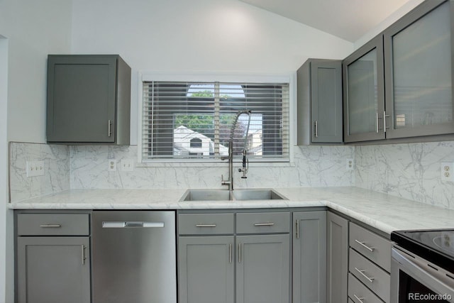 11186 E Baltic Dr, Aurora, CO 80014 - kitchen with stainless steel dishwasher, gray cabinetry, a sink, vaulted ceiling, and backsplash