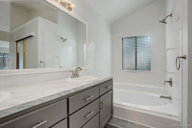 11186 E Baltic Dr, Aurora, CO 80014 - bathroom with vaulted ceiling, vanity, and shower / bathtub combination