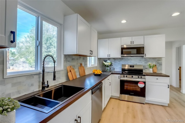 kitchen featuring a healthy amount of sunlight, sink, white cabinetry, and stainless steel appliances