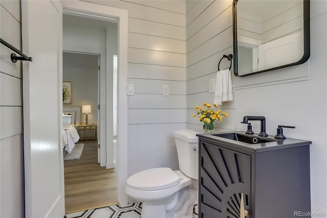 bathroom featuring toilet, vanity, and hardwood / wood-style flooring