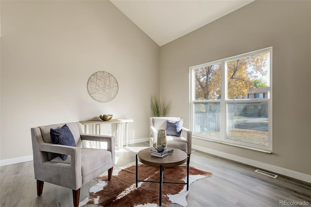 sitting room featuring hardwood / wood-style flooring and lofted ceiling