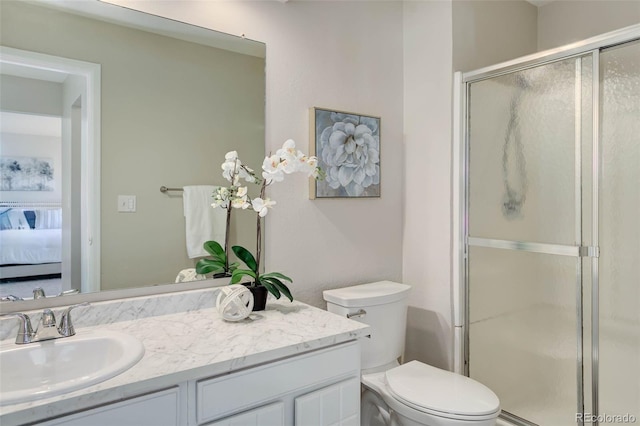 bathroom featuring vanity, an enclosed shower, and toilet