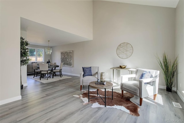 interior space with light hardwood / wood-style flooring, a chandelier, and a high ceiling