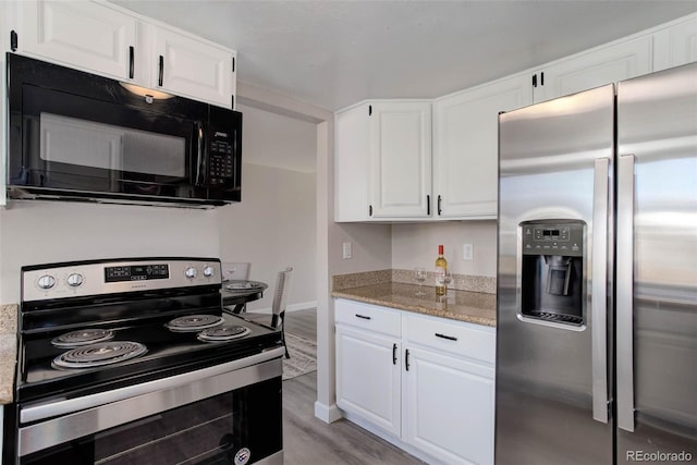 kitchen with light hardwood / wood-style flooring, white cabinets, and appliances with stainless steel finishes