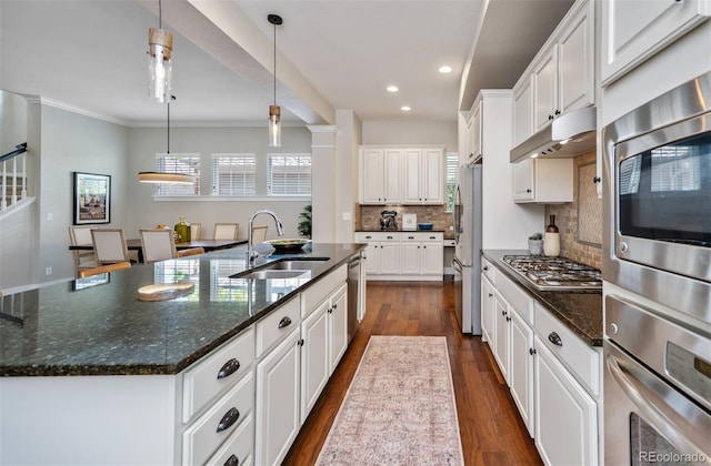 817 Uinta Way, Denver, CO 80230 - kitchen featuring appliances with stainless steel finishes, a sink, under cabinet range hood, decorative backsplash, and a large island
