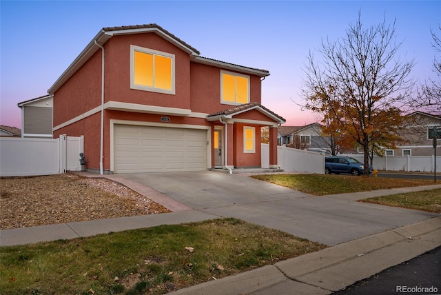 traditional home with an attached garage, fence, driveway, stucco siding, and a tile roof
