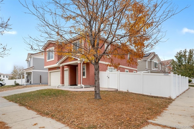 traditional-style home featuring fence and concrete driveway