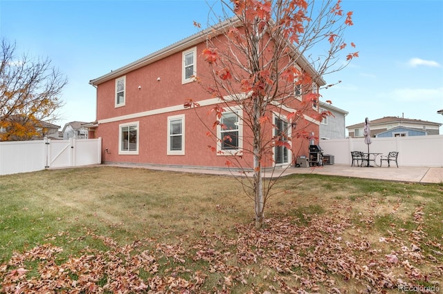 back of property featuring a yard and a patio area