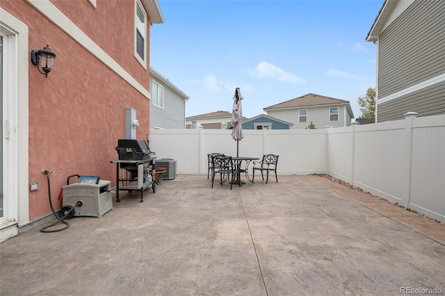 view of patio featuring cooling unit, a fenced backyard, and outdoor dining space