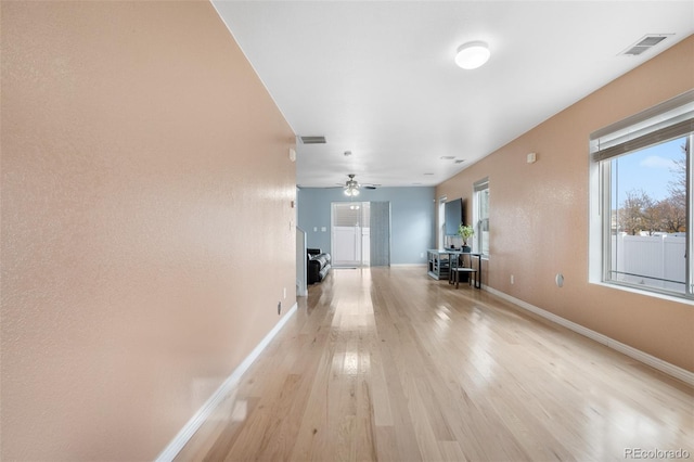 corridor featuring baseboards and light wood-style floors