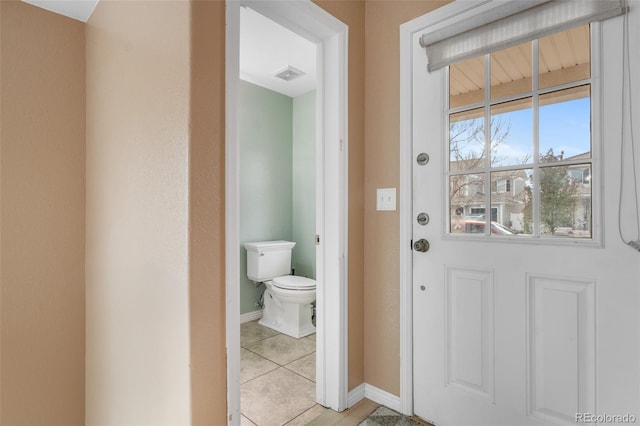 doorway featuring light tile patterned flooring and baseboards