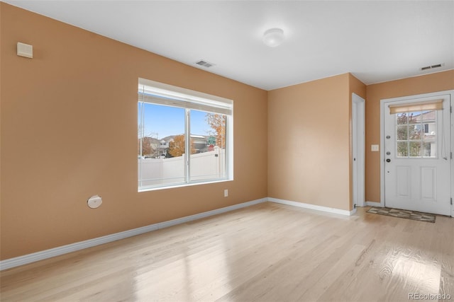 entrance foyer with light wood-type flooring, baseboards, and plenty of natural light