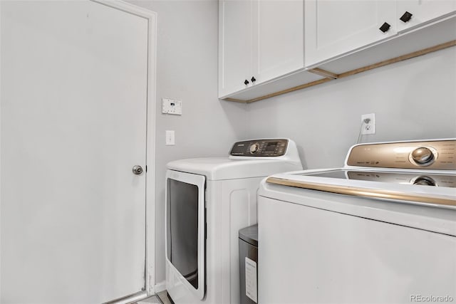 washroom with washer and clothes dryer and cabinets