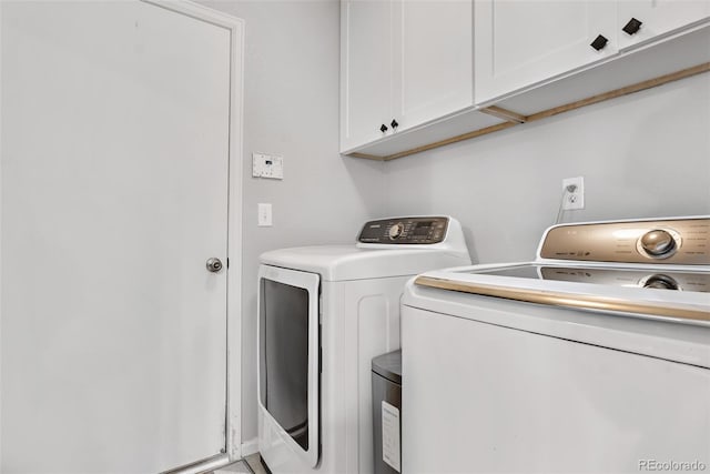 laundry room featuring separate washer and dryer and cabinet space