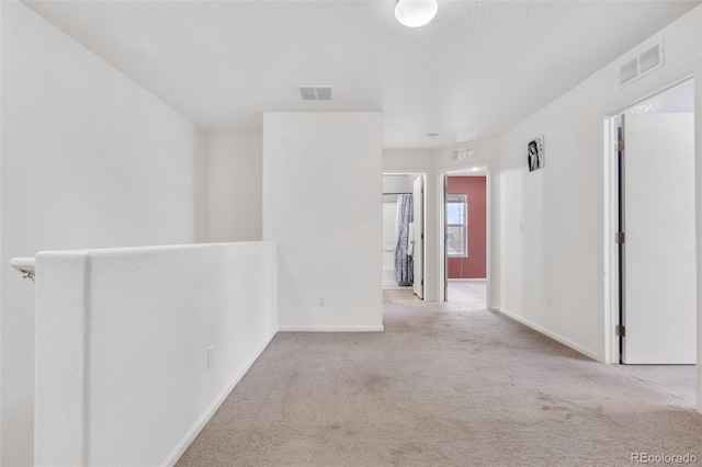 unfurnished room featuring light carpet