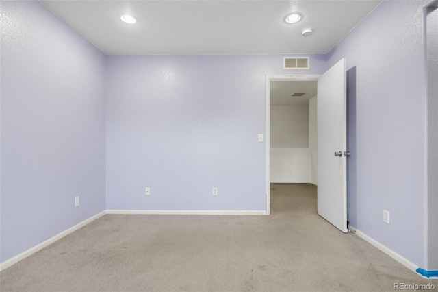 spare room featuring light carpet, baseboards, recessed lighting, and a smoke detector