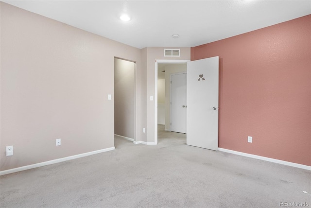 empty room featuring light carpet and baseboards