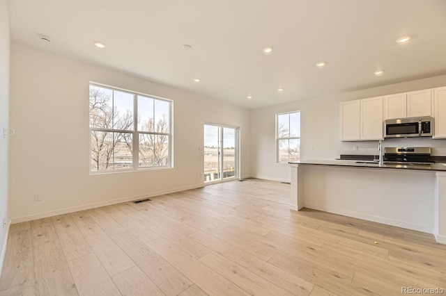 kitchen featuring white cabinets, stainless steel appliances, and light hardwood / wood-style floors