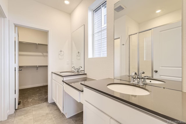 bathroom with tile patterned flooring, vanity, and a shower with shower door