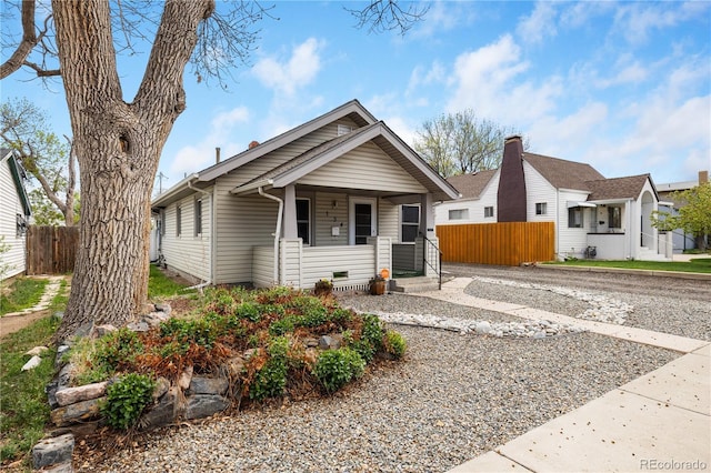 view of front of home featuring covered porch and fence