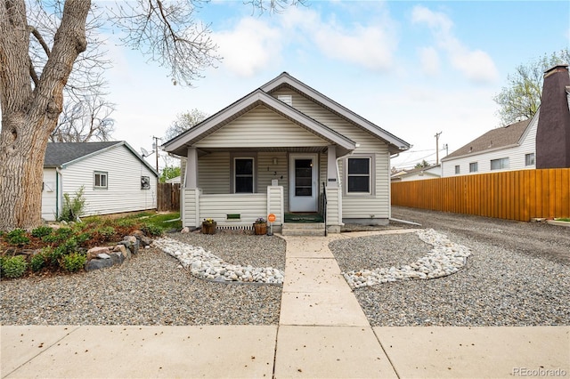 view of front of home with a porch and fence