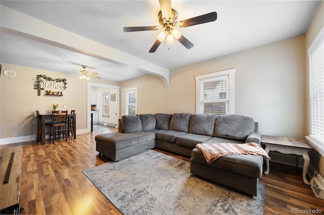living area featuring baseboards, a ceiling fan, and wood finished floors