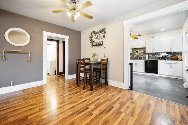 dining room featuring a ceiling fan, baseboards, and light wood-style floors