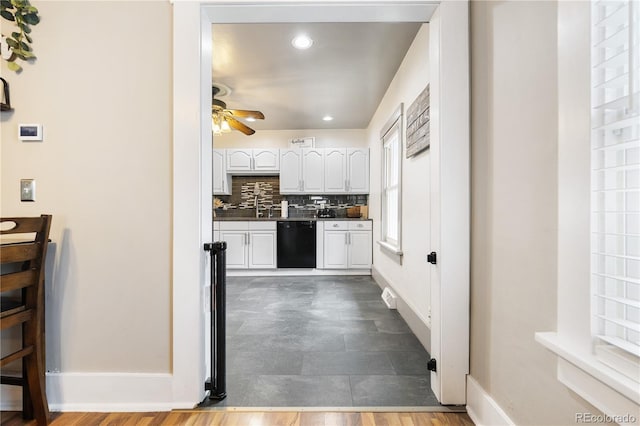 kitchen featuring ceiling fan, decorative backsplash, dark countertops, dishwasher, and white cabinetry