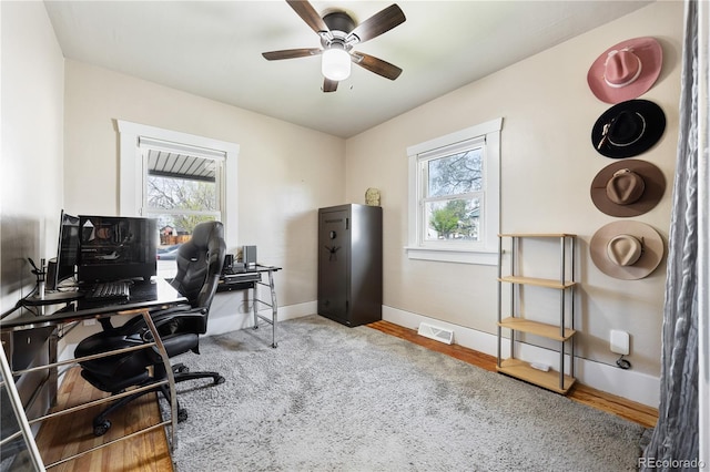 home office with visible vents, baseboards, ceiling fan, and a wealth of natural light