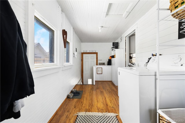 laundry room with laundry area, wood finished floors, and washing machine and clothes dryer