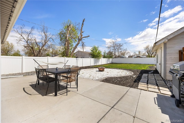 view of patio / terrace with a fenced backyard, outdoor dining area, and an outdoor fire pit
