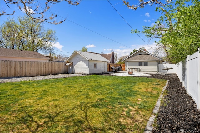 view of yard with an outdoor structure, a fenced backyard, and a patio area
