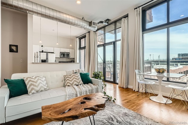 living room featuring a wealth of natural light, light wood finished floors, and a view of city