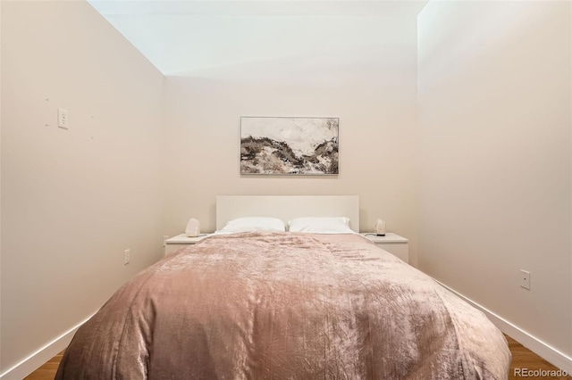 bedroom featuring dark wood-style flooring and baseboards