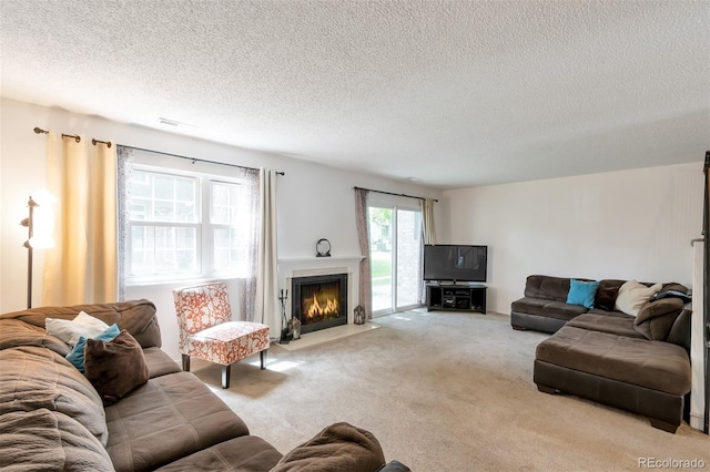 3407 S Ammons St Unit 20-2, Lakewood, CO 80227 - living room with carpet flooring, a textured ceiling, and a fireplace with flush hearth