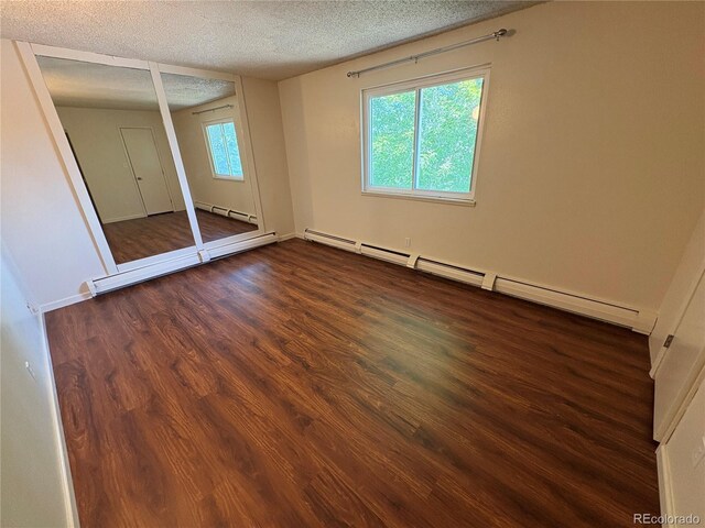 6905 Mariposa St Unit B, Denver, CO 80221 - unfurnished bedroom with a baseboard heating unit, wood finished floors, and a textured ceiling