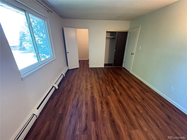 6905 Mariposa St Unit B, Denver, CO 80221 - unfurnished bedroom with baseboard heating, wood finished floors, a closet, and a textured ceiling