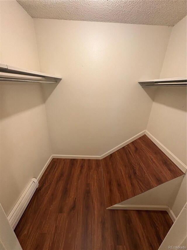 6905 Mariposa St Unit B, Denver, CO 80221 - spacious closet featuring a baseboard heating unit and wood finished floors