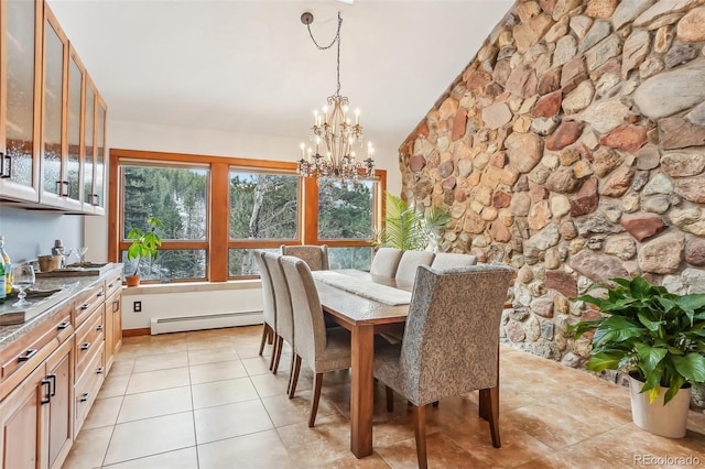 dining space with lofted ceiling, light tile patterned floors, a baseboard radiator, and a chandelier