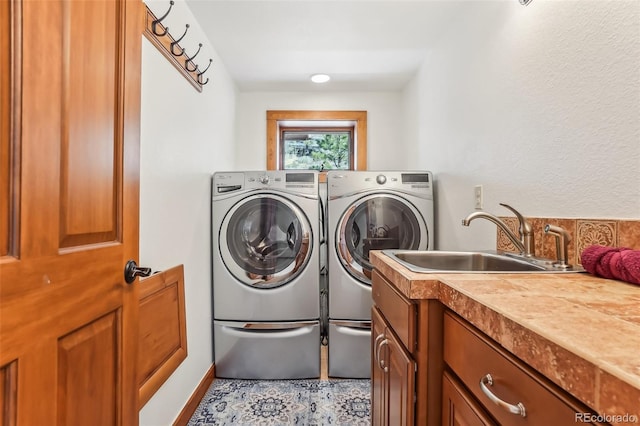 laundry area with independent washer and dryer, a sink, and cabinet space